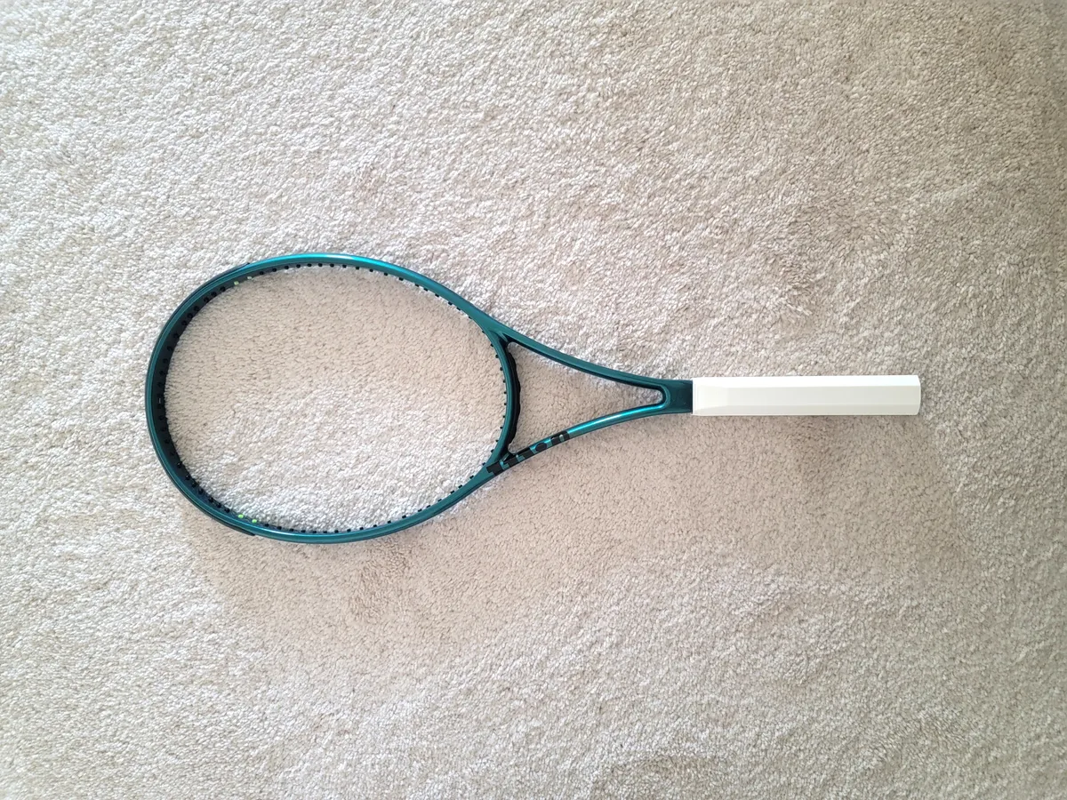 Tennis racket fitted with a white lightweight foamed 3D-printed handle