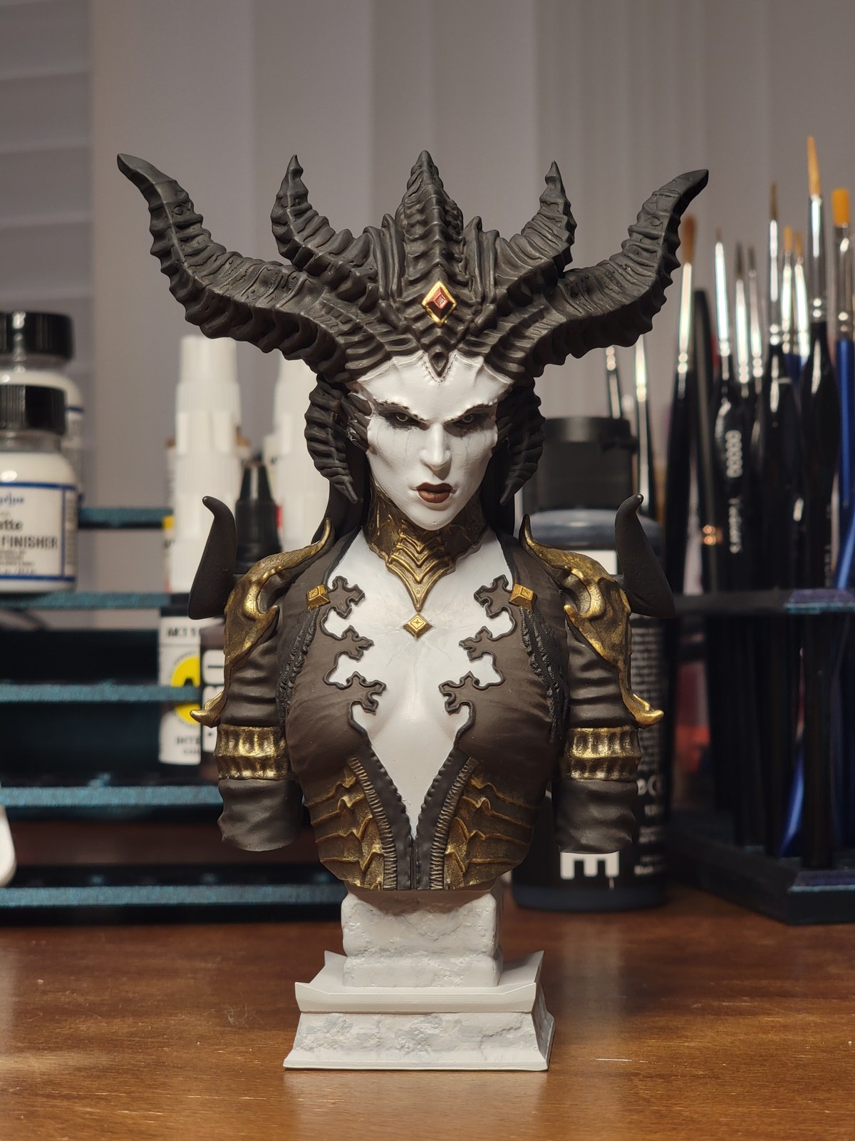 Painted resin character bust displayed in a hobby workspace